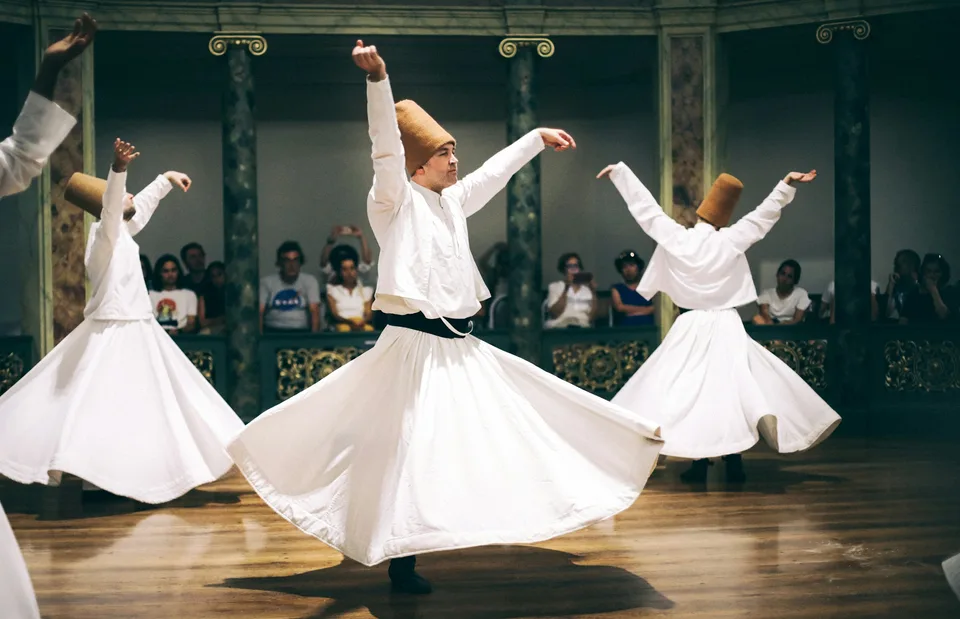 Whirling dervishes performing the sema ceremony on stage