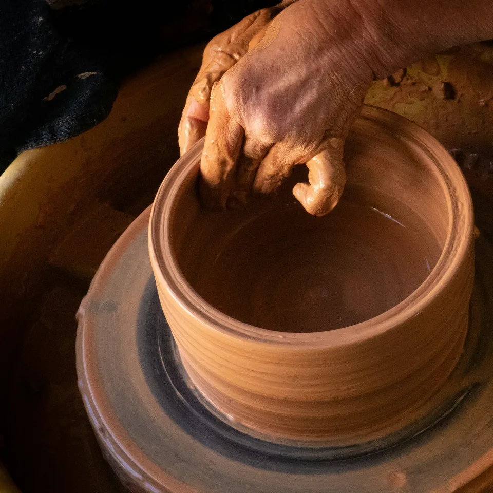 A red clay pot taking shape on a spinning wheel