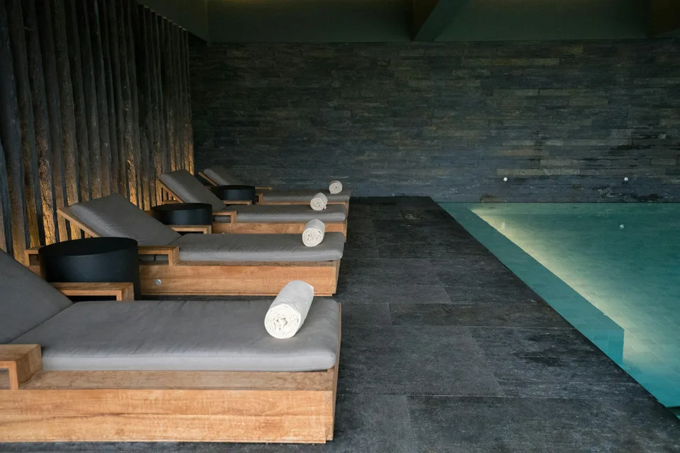 Relaxation loungers beside an indoor spa pool