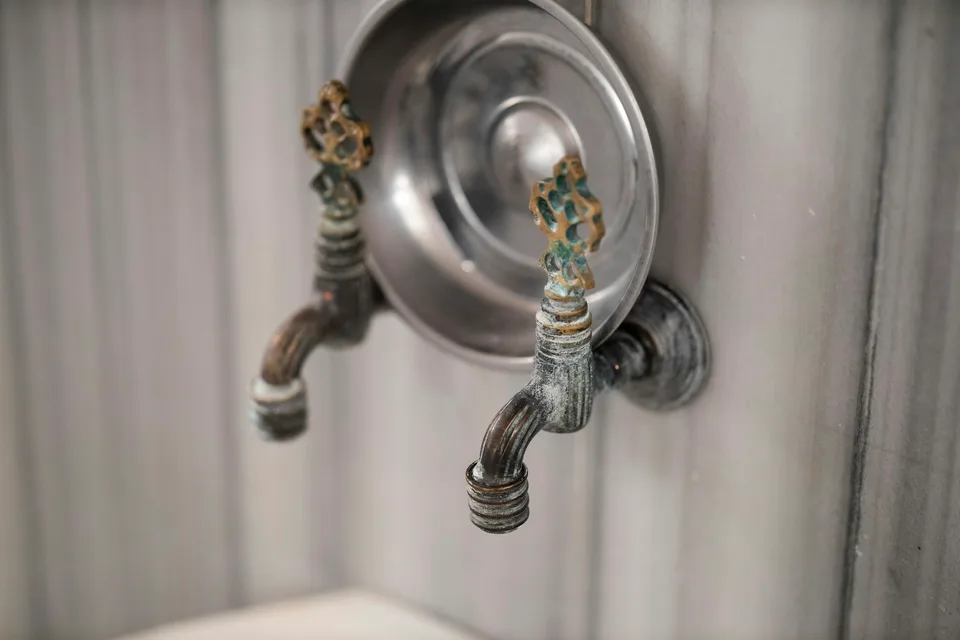 A bath bowl and taps on a marble wall